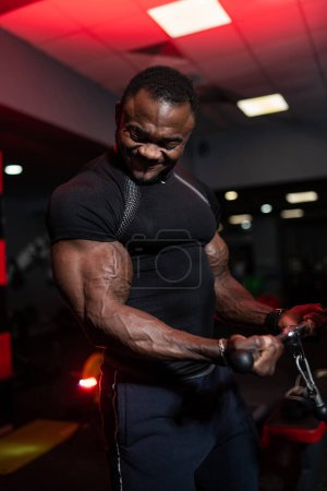 Foto de Culturista fuerte haciendo ejercicio con los músculos del bíceps. Brutal hombre entrenamiento pesado. - Imagen libre de derechos