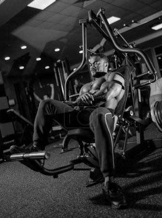 Foto de Cuerpo atlético con entrenamiento muscular. Joven culturista haciendo ejercicio en el gimnasio. - Imagen libre de derechos
