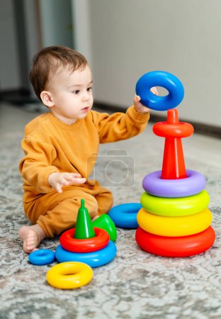 Téléchargez les photos : A baby is playing with a stack of colorful blocks. - en image libre de droit