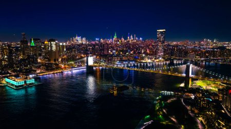 Téléchargez les photos : Lively traffic in never-sleeping New York at night. Scenic view of metropolis and waterscape of the East River from top view. - en image libre de droit