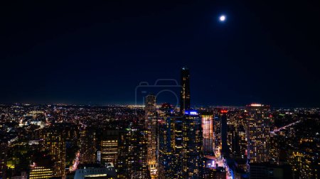Distanciándose de una vista espectacular de Nueva York, los EE.UU. en el paseo marítimo del East River. Skyline de metrópolis por la noche. Perspectiva aérea.