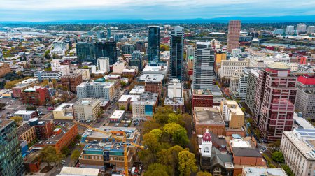Téléchargez les photos : Downtown of Portland, Oregon, the USA with high-rise architecture. Twilight view of the city with mountain silhouettes at backdrop. - en image libre de droit
