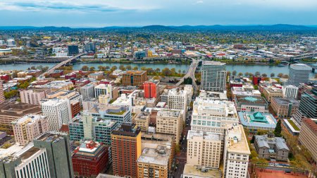 Téléchargez les photos : Centre-ville de Portland, Oregon, États-Unis avec une architecture de grande hauteur. Vue au crépuscule de la ville avec des silhouettes de montagne en toile de fond. - en image libre de droit