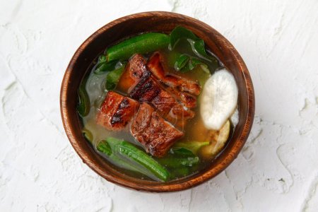 Téléchargez les photos : Photo de la nourriture philippine fraîchement cuite appelée Sinigang na liempo croustillant ou ventre de porc croustillant dans la soupe tamarin. - en image libre de droit