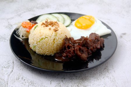 Photo of freshly cooked Filipino food called Tapsilog or thin beef slices, egg and fried rice.