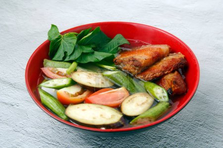 Téléchargez les photos : Photo de la nourriture philippine fraîchement cuite appelée Sinigang na liempo croustillant ou ventre de porc croustillant dans la soupe tamarin. - en image libre de droit