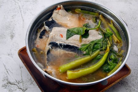 Photo of freshly cooked Filipino food called Sinigang na Bangus or milkfish with vegetables in tamarind soup.
