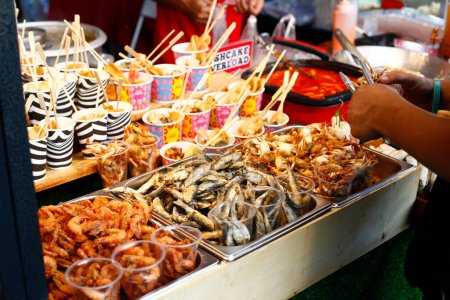 Foto von verschiedenen gebratenen Meeresfrüchten, die an einem Streetfood-Wagen verkauft werden.