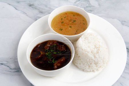 Foto von frisch gekochtem philippinischem Essen namens Beef Pares oder Rinderbrust, serviert mit Reis und Suppe.