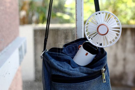 Photo of a portable rechargeable electric fan in a bag.