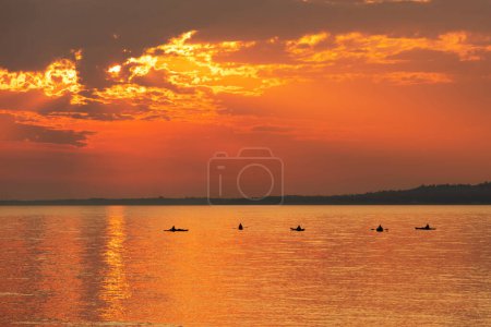 Photo for Kayakers on Lake Huron with a beauiful sunset veiwed from Mackinac Island, Michigan. - Royalty Free Image