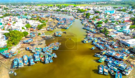 Photo for La Gi fishing village seen from above with hundreds of boats anchored along both sides of river to avoid storms near estuary, this is also a large fishing port providing seafood in central Vietnam - Royalty Free Image