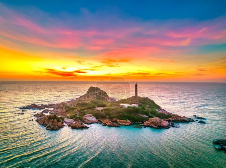 Photo for Landscape of small island with ancient lighthouse at sunrise sky is beautiful and peaceful. This is only ancient lighthouse is located on island in Vietnam - Royalty Free Image
