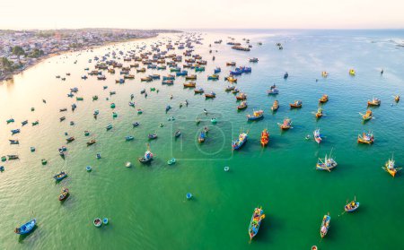 Téléchargez les photos : Vue aérienne du village de pêcheurs de Mui Ne le matin avec des centaines de bateaux ancrés pour éviter les tempêtes, c'est une belle baie dans le centre du Vietnam - en image libre de droit