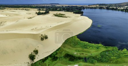Téléchargez les photos : Contraste géographique entre le sable et l'eau près de Mui Ne, Vietnam. Le désert de Mui Ne du Vietnam est un désert en Asie du Sud-Est - en image libre de droit