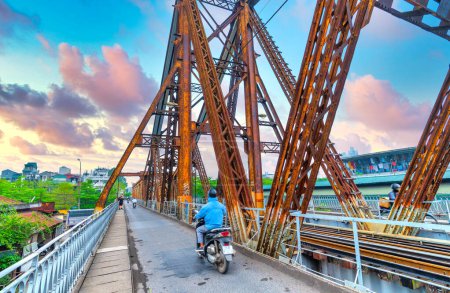 Photo for Hanoi, Vietnam - May 6th, 2024: People traffic on railroad tracks leading over Long Bien Bridge, It's constructed at the beginning of 20th century was designed by Gustave Eiffel in Hanoi, Vietnam - Royalty Free Image