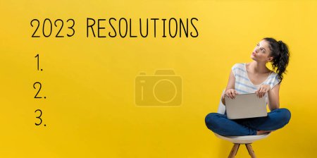 Téléchargez les photos : 2023 Résolutions avec une jeune femme utilisant un ordinateur portable - en image libre de droit