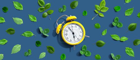 Reloj despertador vintage amarillo con hojas verdes - plano