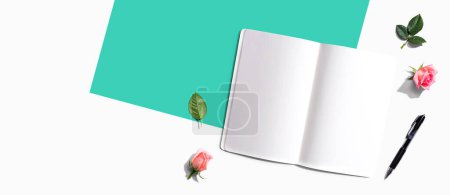 Photo for Open notebook or diary with a pen from above with rose buds- flat lay - Royalty Free Image