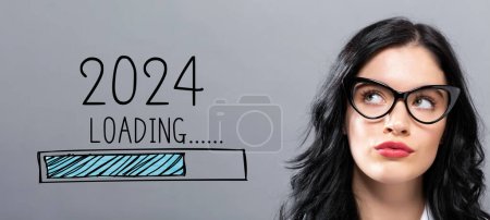 Téléchargez les photos : Chargement de la nouvelle année 2024 avec une jeune femme d'affaires dans un visage réfléchi - en image libre de droit
