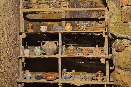 Photo for Old wooden shelf with vintage pottery in house of the ancient abandoned village Celleno, Viterbo, Lazio, Italy - Royalty Free Image
