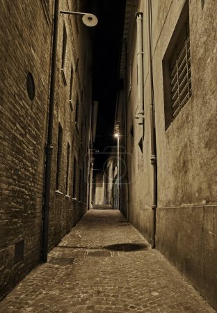 Photo for Rimini, Emilia Romagna, Italy: dark narrow alley at night in the old town of the Italian city on the Adriatic sea coast - Royalty Free Image