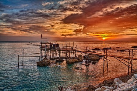 Photo for Rocca San Giovanni, Chieti, Abruzzo, Italy: landscape of the Adriatic sea coast at dawn with an ancient fishing hut trabocco, the typical Mediterranean wooden pilework - Royalty Free Image