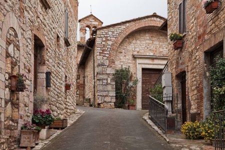 Corciano, Perugia, Umbría, Italia: callejuela estrecha y la antigua iglesia de San Cristoforo, ahora sede de un museo, en el casco antiguo del pintoresco pueblo