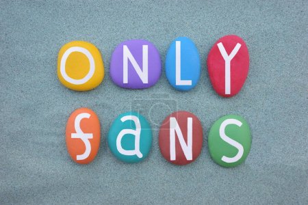Only Fans, creative message composed with multi colored stone letters over green sand