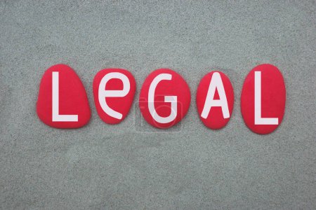 Legal, in Bezug auf das Gesetz, Wort, das mit handgemalten roten Steinbuchstaben über grünem Sand zusammengesetzt ist