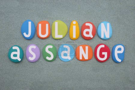 Julian Paul Assange (geboren am 3. Juli 1971 in Hawkins), australischer Herausgeber, Verleger und Aktivist, der WikiLeaks 2006 gründete. Kreative Feier mit handgemalter Komposition aus mehrfarbigen Steinbuchstaben über grünem Sand