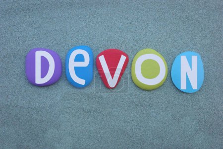 Devon, nombre de pila masculino compuesto por letras de piedra multicolor pintadas a mano sobre arena verde