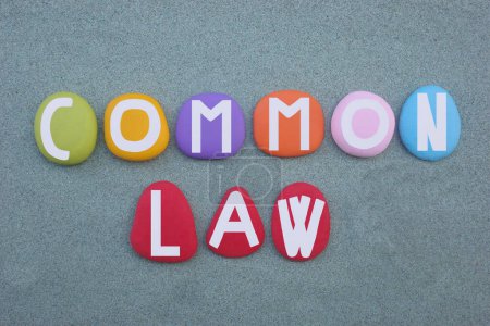 In law, common law is the body of law created by judges and similar quasi-judicial tribunals by virtue of being stated in written opinions, creative text composed with hand painted multi colored stone letters over green sand