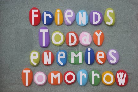 Amigos hoy, enemigos mañana, diseño de póster creativo compuesto con letras de piedra multicolor sobre arena verde