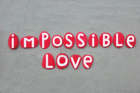 Impossible love, creative phrase composed with hand painted red colored stone letters over green sand