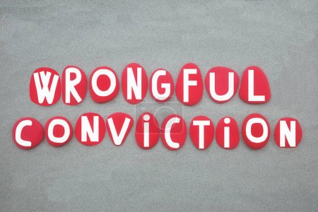 Wrongful conviction, a conviction of a person for a crime that he or she did not commit, creative text composed with red colored stone letters over green sand