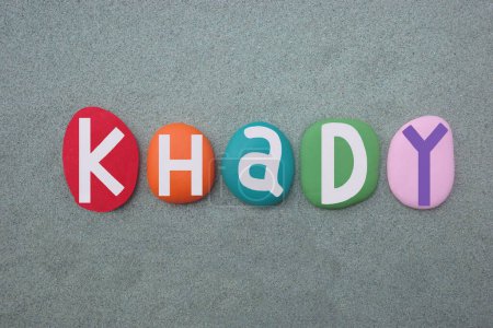 Celebración de Khady, nombre femenino con letras de piedra multicolor sobre arena verde