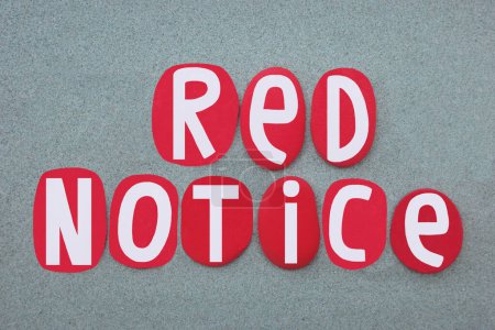 Red notice, international alert circulated by Interpol to communicate information about crimes, criminals, and threats by police in a member state to their counterparts around the world composed with red colored stone letters over green sand