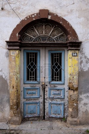 Traditional vintage closed blue wooden door outside a demolished house. Abandoned houses. Cyprus