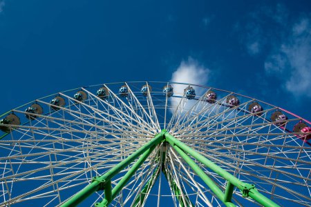 Foto de Rueda de la fortuna aislada en el fondo azul del cielo, divirtiéndose en un parque de atracciones - Imagen libre de derechos