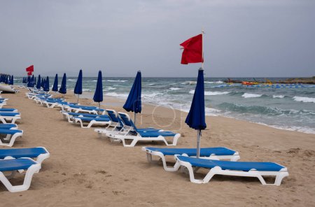 Photo for Red flag on the stormy beach. Dangerous for swimming. Fig tree bay Protaras Cyprus - Royalty Free Image
