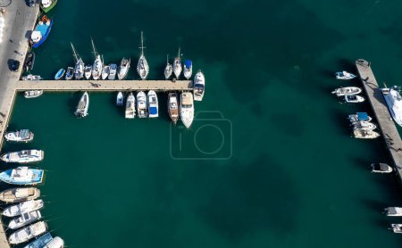 Photo for Drone aerial scenery of a fishing port. Fishing boats and yachts moored in the harbour. Zygi marina Cyprus - Royalty Free Image