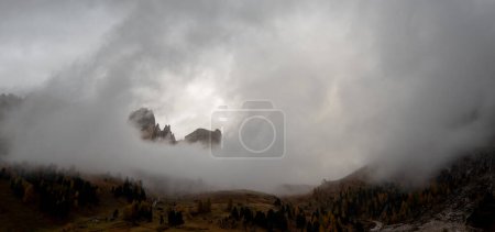 Photo for Foggy mountain landscape at sunrise in the valley in autumn. Passo Gardena Dolomites at South Tyrol in Italy. - Royalty Free Image