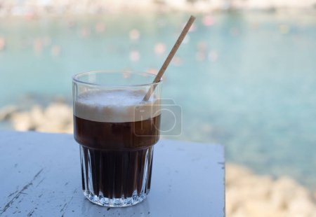Photo for Fredo espresso iced coffee on the beach. Refreshment outdoor. Black coffee. - Royalty Free Image