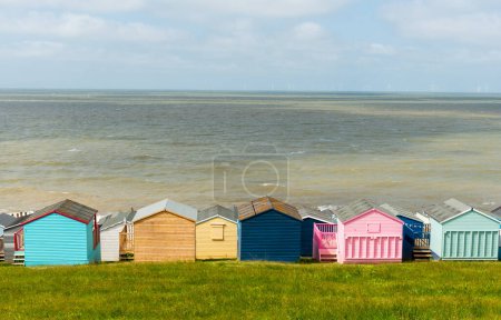 Bunte Ferienhäuser am Strand mit Blick auf das ruhige blaue Meer. Whitstable, Kent Südostengland