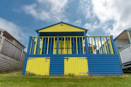 Colourful wooden each hut, holiday house against cloudy sky. Whitstable Kent, United Kingdom