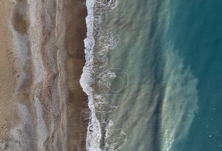 Drone widok z lotu ptaka burzliwe fale oceaniczne łamanie na piaszczystej plaży. Kontekst natury.