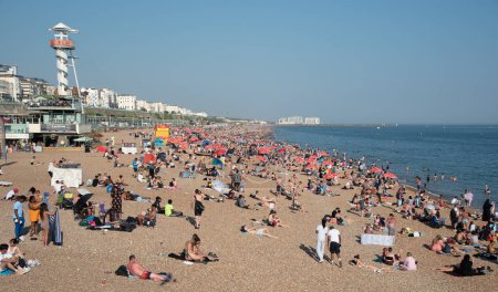 Photo for Brighton, United Kingdom, June 10 2023: Crowd of British people sunbathing swimming and relaxing in the beach at summer. Leisure time outdoor - Royalty Free Image