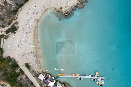 Drone top view of idyllic sandy holiday beach. Konnos Bay beach people relaxing and enjoying summer holidays. Protaras Cyprus