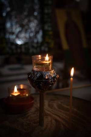 Candle light with flame glowing in oil in a church. Symbol of faith and spirit.